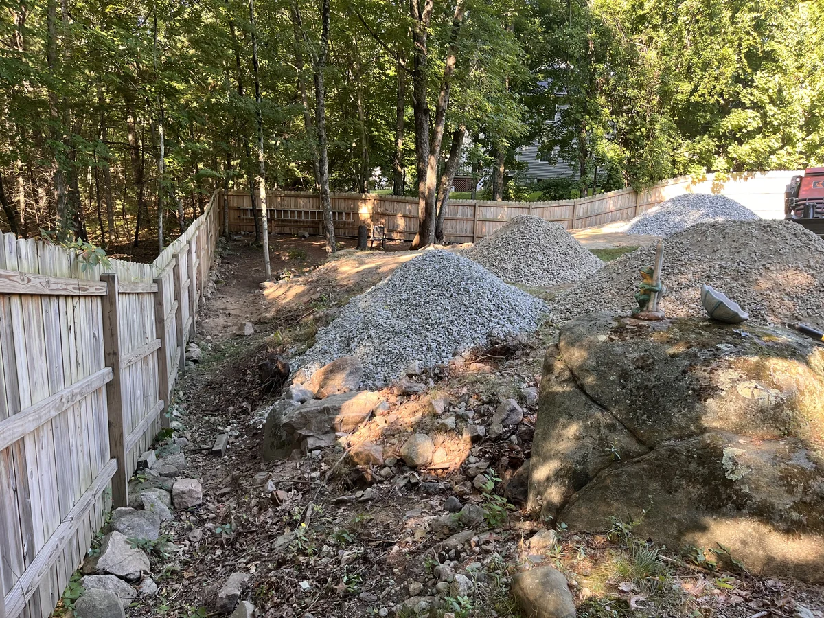 Fenced backyard gravel delivered and spread into a clean, level surface - Before