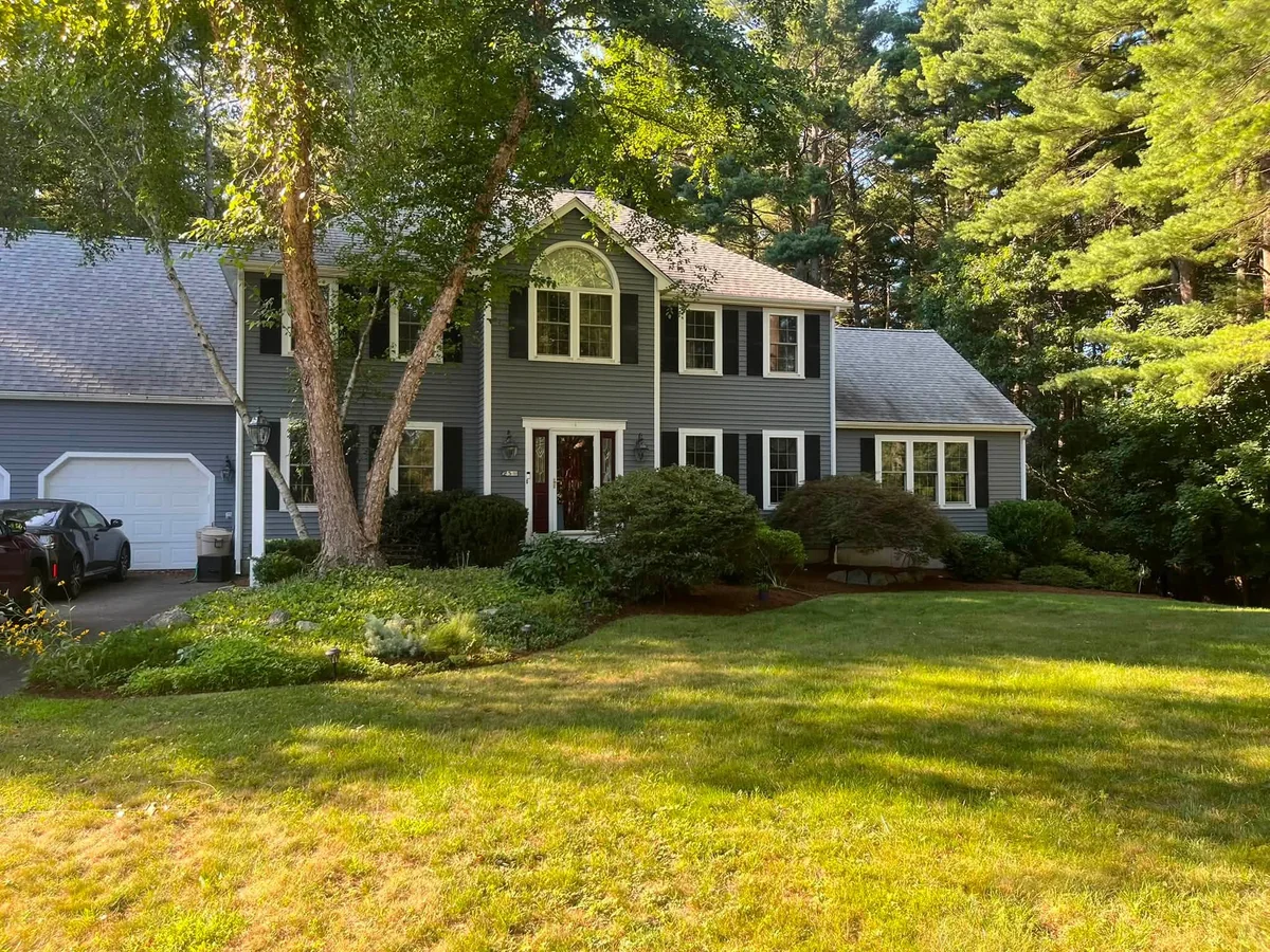 Overgrown colonial front yard shrubs and beds pruned and cleaned up - After